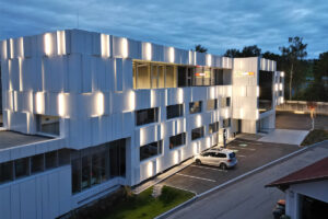 Schmid Baugruppe Dachbau Fassadenverleidung Hinterlueftete Fassade Frifacade Aluminium Verbundplatten Etalbond Gebauedehuelle Modern Weiss Beleuchtet